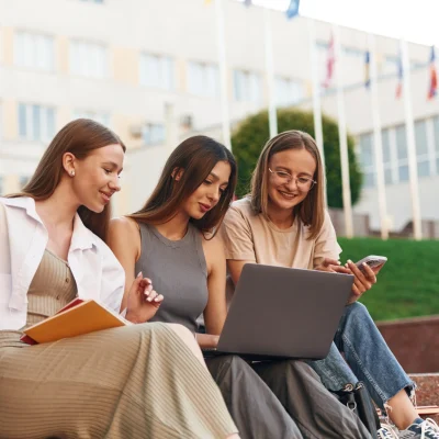 Studentki Collegium Verum uczące się razem przed budynkiem uczelni